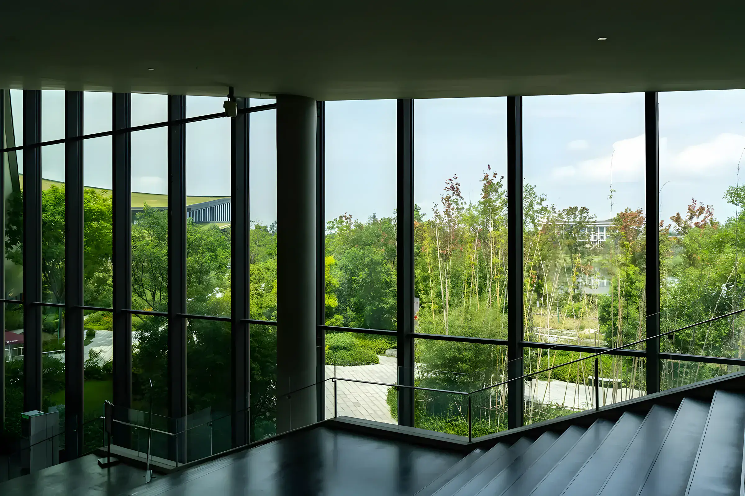 Interior moderno con grandes ventanales de vidrio y vistas a los árboles