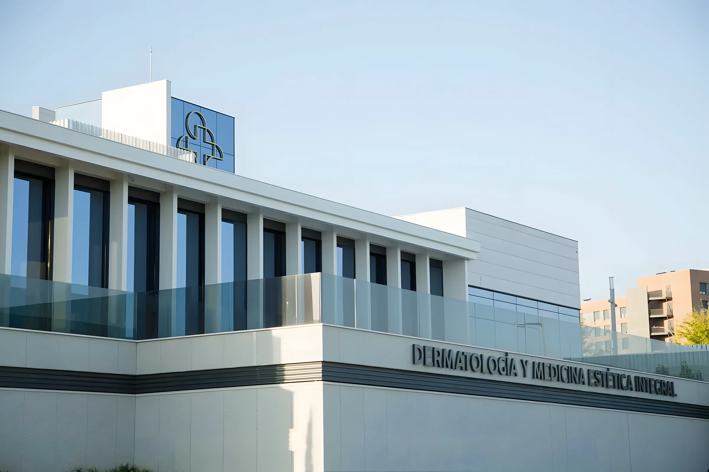 Edificio de clínica con fachada de paneles claros y carpintería exterior oscura