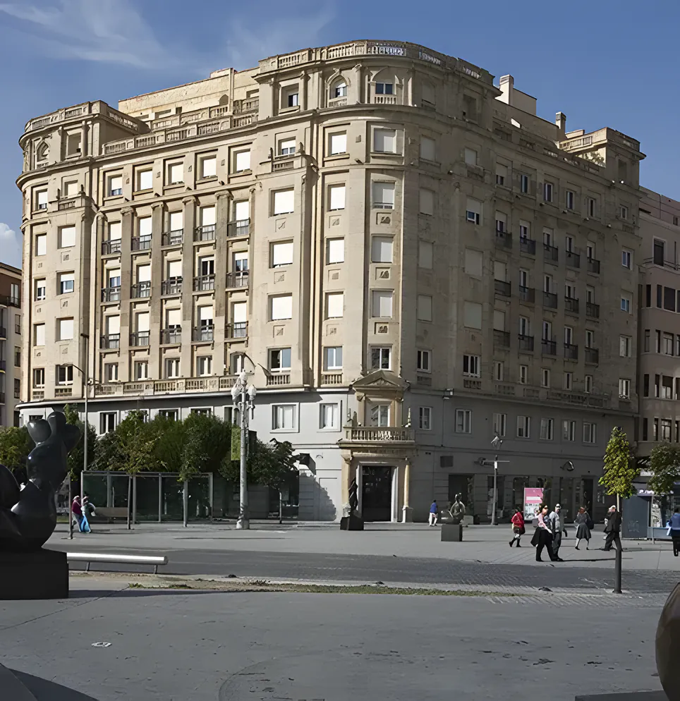 Edificio histórico de piedra, de siete plantas y con balcones, en una plaza