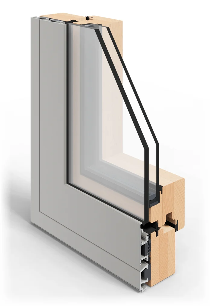 Esquina seccionada de una ventana mixta de la serie Astro 11, vista desde fuera: aluminio gris al exterior y madera de haya al interior y vidrio de 28 mm